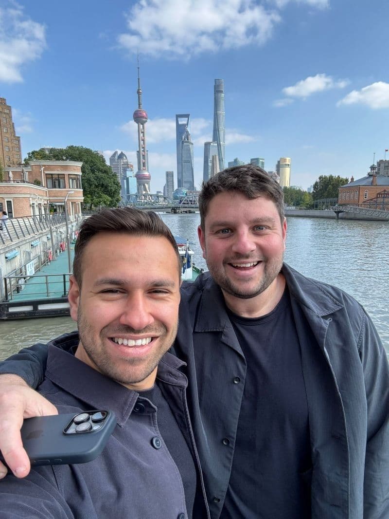 GoPlaces co-founders Sam Jacobs and Jack Finger by the river in Shanghai, with the city skyline behind them